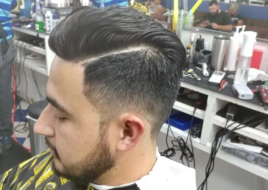 A slicked-back pompadour with a hard part